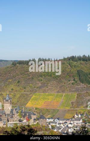 Ein malerischer Blick auf ein Schloss, umgeben von Weinbergen und Hügeln unter einem klaren blauen Himmel Stockfoto