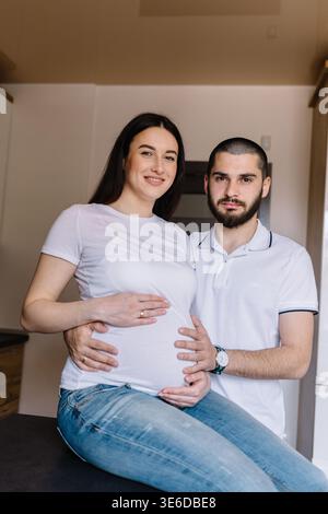 Schwangere Paare. Glückliche Familie. Schwangere Frau mit Ehemann in der Küche. Stockfoto