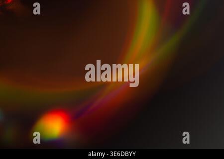 Abstraktes Bild mit farbenfrohen Lichtmustern in Rot, Gelb und Grün, die vor dunklem Hintergrund wirbeln und einen lebendigen visuellen Effekt erzeugen Stockfoto