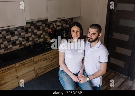 Schwangere Paare. Glückliche Familie. Schwangere Frau mit Ehemann in der Küche. Stockfoto