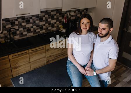 Schwangere Paare. Glückliche Familie. Schwangere Frau mit Ehemann in der Küche. Stockfoto