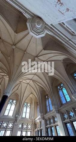 Abgewinkelter Blick auf die gotische Rippengewölbedecke mit sich kreuzenden Bögen und Fenstern im Schloss Malbork in Polen. Architektur, Struktur und Designdetails Co Stockfoto