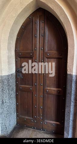 Alte Holztür mit Metallbolzen und Bogenrahmen im Schloss Malbork in Polen. Architektur, Geschichte und Kulturerbe. Stockfoto