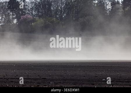 Leuthen, Deutschland. April 2026. Ein starker Wind weht Sand über ein Feld. Das Wetter am Ostermontag im Süden Brandenburgs ist sehr sonnig, mit Temperaturen unter 15 Grad Celsius und starkem Wind. Das Wetter wird in den nächsten Tagen ähnlich bleiben. Vermerk: Frank Hammerschmidt/dpa/Alamy Live News Stockfoto