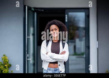 Selbstbewusster Teenager-Schüler, der vor dem Schulgebäude steht. Stockfoto
