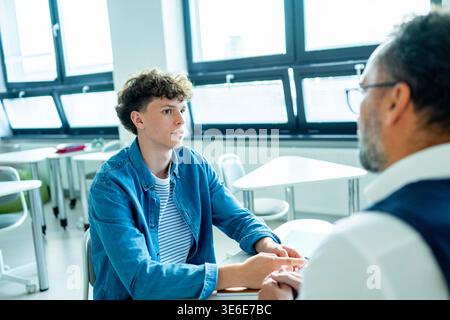 Der Lehrer unterstützt den Lernenden mit Lernschwierigkeiten während des Unterrichts. Stockfoto