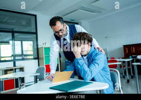 Der Lehrer unterstützt den Lernenden mit Lernschwierigkeiten während des Unterrichts. Stockfoto