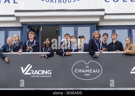 Junge Studenten der Oxford University schreien und klatschen, um den Teamgeist während des Bootsrennens vom Imperial College Boat House balco zu feiern Stockfoto