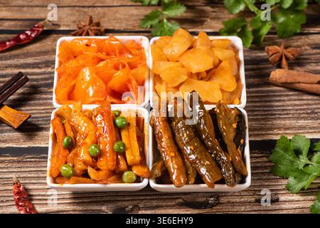 Vier Schüsseln mit einer Vielzahl von bunten fermentierten Gemüsesorten auf hölzernem Hintergrund Stockfoto
