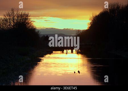 Glasgow, Schottland, Großbritannien. April 2026. Wetter in Großbritannien: Sonnenuntergang auf dem Forth und clyde Kanal im Nordwesten der Stadt. Die Regenfälle im April machten dem warmen Wetter Platz, da der erste Hinweis auf das vorhergesagte Sommerwetter über der Skyline des West End und dem hochstehenden Gebäude im Anniesland Court Tower in schottland sichtbar wird. Credit Gerard Ferry/Alamy Live News Stockfoto