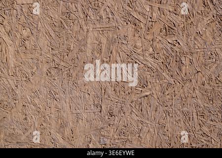 Holzverbundplatten aus komprimierten Holzspänen und Harz. Natürliche, rustikale Textur, die bei Tageslicht im Freien hervorgehoben wird. Stockfoto