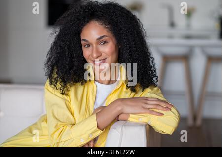 Schöne junge langhaarige Frau in gelber Jacke Stockfoto