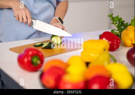 Nahaufnahme von weiblichen Händen, die Gemüse schneiden Stockfoto
