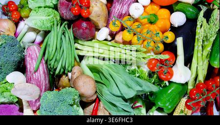 Frisches Gemüse auf einem Tisch, bereit zum Kochen in verschiedenen Farben und Arten in einer Küche während der Tageslichtstunden Stockfoto