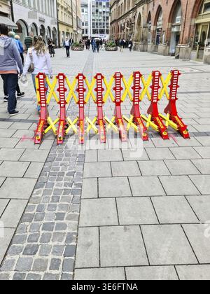München, Deutschland - 22. Juni 2024: Rote und gelbe Absperrungen blockieren den Zugang zur Kaufingerstraße, einer Fußgängerzone in München Stockfoto