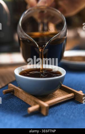 Eine Nahaufnahme des Dampfkaffees, der in eine Tasse gegossen wird, zeigt seine satte Farbe und den Brühvorgang Stockfoto