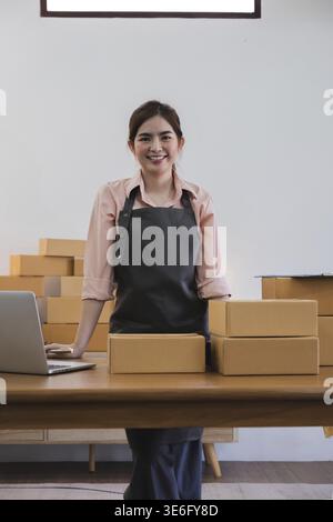 Porträt einer asiatischen jungen Frau KMU, die zu Hause mit einer Box arbeitet der Arbeitsplatz.Start-up Kleinunternehmer, Kleinunternehmer KMU oder Freiberufler Stockfoto