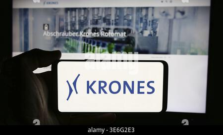 Stuttgart, Deutschland - 08.05.2024: Person mit Handy mit Logo des deutschen Ingenieurunternehmens Krones AG vor der Business-Webseite. Konzentrieren Sie sich auf Pho Stockfoto