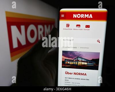 Stuttgart, Deutschland - 08.05.2024: Handybesitzer mit Website der Norma Lebensmittelfilialbetrieb Stiftung Co. KG mit Logo. Fokus Stockfoto