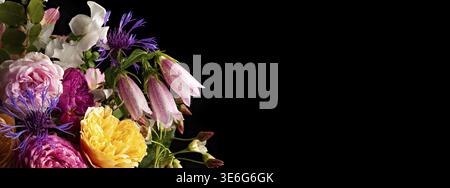 Buntes Blumenarrangement auf schwarzem Hintergrund: Rosen, Lilien und Wildblumen in atemberaubendem Kontrast Stockfoto