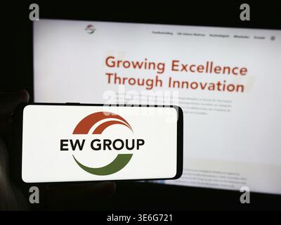 Stuttgart, Deutschland - 08.05.2024: Person mit Smartphone mit Logo des deutschen Tierzuchtunternehmens EW Group GmbH vor der Website. Konzentrieren Sie sich auf Stockfoto