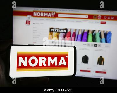 Stuttgart, Deutschland - 08.05.2024: Person mit Smartphone mit Logo der Norma Lebensmittelfilialbetrieb Stiftung Co. KG vor der Website. F Stockfoto
