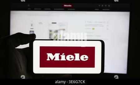 Stuttgart, Deutschland - 08.05.2024: Person mit Mobiltelefon mit Logo des deutschen Haushaltsgeräteunternehmens Miele Cie. KG vor der Business-Webseite. Stockfoto
