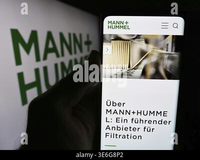 Stuttgart, Deutschland - 08.05.2024: Person mit Smartphone und Website des deutschen Unternehmens Mann Hummel International GmbH Co. KG vor dem Logo. Fokussieren Stockfoto