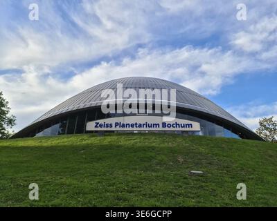 Bochum, Deutschland - 25. September 2025: Zeiss Planetarium Bochum Kuppel über grüner Parklandschaft, moderne geschwungene Architektur in Deutschland, ein Wahrzeichen für Stockfoto