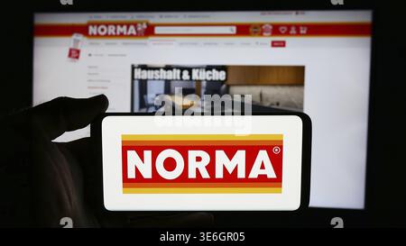 Stuttgart, Deutschland - 08.05.2024: Person mit Mobiltelefon mit Logo der Norma Lebensmittelfilialbetrieb Stiftung Co. KG vor der Webseite. Fo Stockfoto