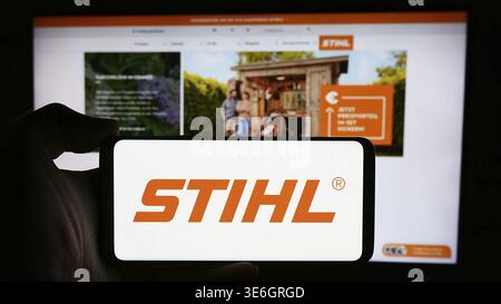 Stuttgart, Deutschland - 08-02-2024: Person mit Mobiltelefon mit Logo des deutschen Stromversorger Stihl Holding AG Co. KG vor der Webseite. Foc Stockfoto