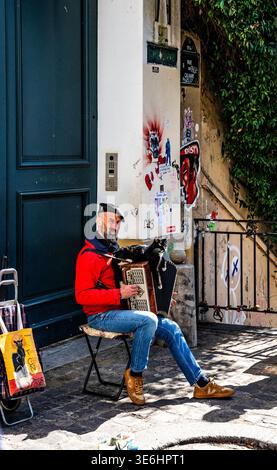 Akkordeonspieler mit Katze am Place du Calvaire, einem malerischen Platz in der Nähe von Sacré-Cœur, Montmartre, in Paris, Frankreich. Stockfoto