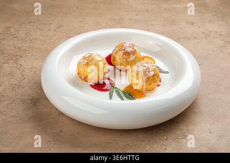 Syrniki-Käsepfannkuchen mit Beerensauce auf Teller Stockfoto