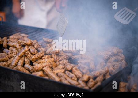 Blick auf brausende Cevapi auf einem Rauchgrill, zartes Fleisch, das unter einem Spatel gebräunt wird, ein fest für die Sinne, duftender Dampf steigt, Pula, Istria Co Stockfoto