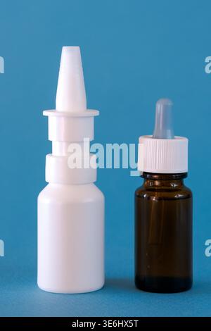 Flaschen mit Tropfen und Nasentropfen auf den Hintergrund sprühen. Medizin gegen Kälte Stockfoto