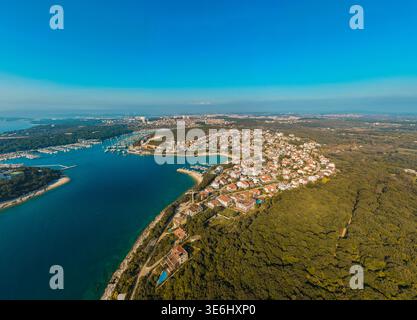 Blick aus der Vogelperspektive auf die Küste, wo Terrakotta-Dächer auf die azurblaue Adria treffen und grüne Hügel die moderne Architektur umhüllen, Pula, County Istrien, CR Stockfoto