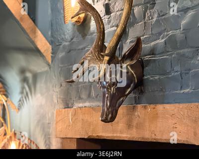 Hirschkopf-Wandskulptur über Holzbalken im privaten Speisesaal des Hotels Indigo Stratford-upon-Avon, dem zuvor restaurierten Tudor Falcon Hotel. Stockfoto