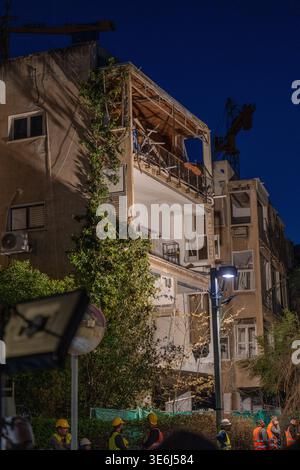 Tel Aviv Israel 23. März 2026. Die Arbeiter räumen die Trümmer und die verbliebenen Strukturen, die durch einen direkten Treffer eines iranischen Raketenrettungsteams beschädigt wurden, durchsuchen nach einem Raketenangriff eingestürzte Wohnschutt in Zentral-Israel, inmitten von Zerstörungen mit mehreren Aufprallstellen und erheblichen Schäden an Wohngebäuden in zivilen Gebieten Stockfoto