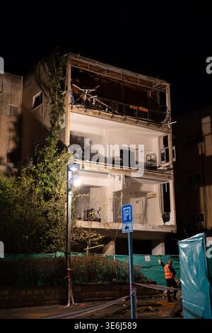 Tel Aviv Israel 23. März 2026. Die Arbeiter räumen die Trümmer und die verbliebenen Strukturen, die durch einen direkten Treffer eines iranischen Raketenrettungsteams beschädigt wurden, durchsuchen nach einem Raketenangriff eingestürzte Wohnschutt in Zentral-Israel, inmitten von Zerstörungen mit mehreren Aufprallstellen und erheblichen Schäden an Wohngebäuden in zivilen Gebieten Stockfoto