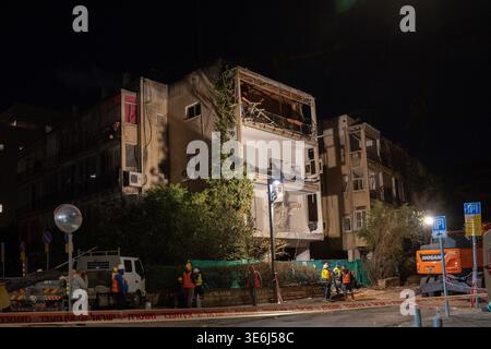 Tel Aviv Israel 23. März 2026. Die Arbeiter räumen die Trümmer und die verbliebenen Strukturen, die durch einen direkten Treffer eines iranischen Raketenrettungsteams beschädigt wurden, durchsuchen nach einem Raketenangriff eingestürzte Wohnschutt in Zentral-Israel, inmitten von Zerstörungen mit mehreren Aufprallstellen und erheblichen Schäden an Wohngebäuden in zivilen Gebieten Stockfoto