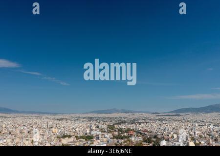 Panoramablick auf die Stadt Athen unter hellblauem Himmel mit fernen Bergen, Griechenland Stockfoto
