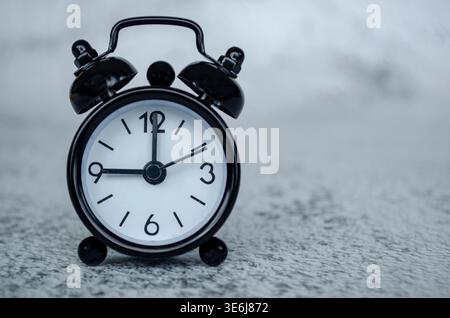 Einfaches Bild des Weckers im Studiostil, das ein Tagesplankonzept um neun Uhr mit gedämpften Tönen und ausgewogener Komposition veranschaulicht. Stockfoto