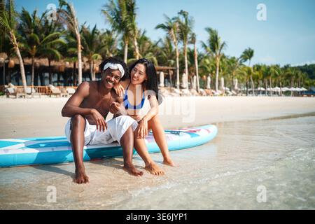 Reines Glück. Ein junges, vielseitiges, multiethnisches Paar genießt jeden Moment ihres tropischen Urlaubs Stockfoto
