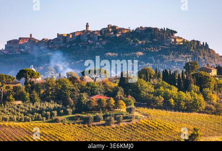 Das antike Dorf Pienza liegt auf einem Hügel mit Blick auf farbenfrohe Herbstberge und Olivenhaine in der Landschaft von Siena. Stockfoto