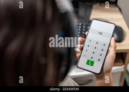 Junge Person, die 112 auf einem Smartphone für dringende Notfallhilfe wählt Stockfoto