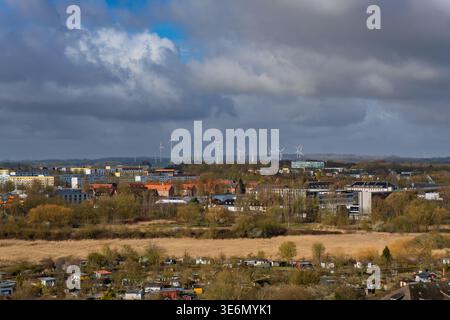 Wismar, Deutschland - 30. März 2026: Ein erhöhter Blick auf das Stadtbild Wismars mit Wohnvierteln und einem großen Windturbinenpark im dist Stockfoto