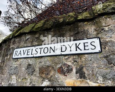 Verwittertes Ravelston Dykes-Schild an einer strukturierten Steinmauer in Edinburgh, Schottland, Großbritannien. Stockfoto