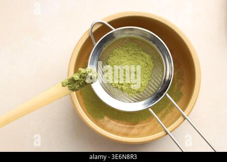 Matcha-Pulver in die Schüssel am Lichttisch, Draufsicht Stockfoto