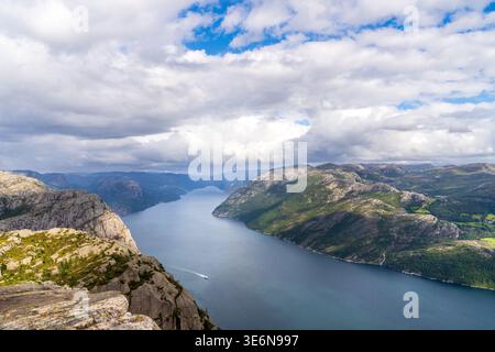 Eine majestätische Hochwinkelperspektive auf den Lysefjord in Norwegen. Das Bild zeigt tiefblaues Wasser, eingerahmt von hoch aufragenden Granitklippen und grünem Mo Stockfoto