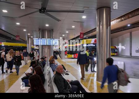 Mallorca. Spanien - 07. April 2026: Pendler sitzen auf Bänken am Busbahnhof Palma, während die TIB-Busse an den nummerierten Toren in der Nähe des Digital ankommen Stockfoto